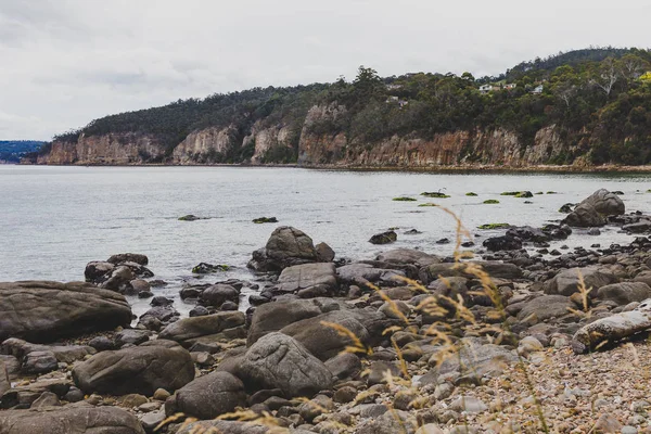 Playa desierta en Hobart, Tasmania con rocas en primer plano —  Fotos de Stock