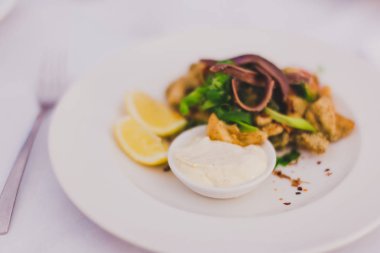 Kızarmış kalamar sosu ve limon dilimleri ile tabak