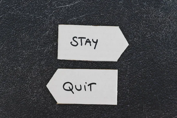 Stay vs quit text on signs pointing at opposite directions about — Stock Photo, Image
