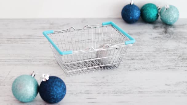 Hand Placing Christmas Baubles Shopping Basket Blue Silvery Tones — Stock Video