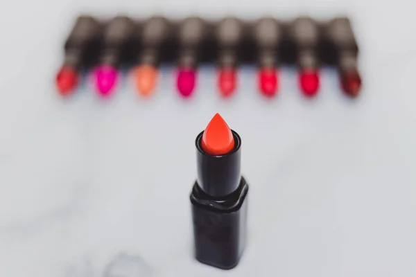 Maquillaje bodegón con grupo de lápices labiales de colores alineados y — Foto de Stock