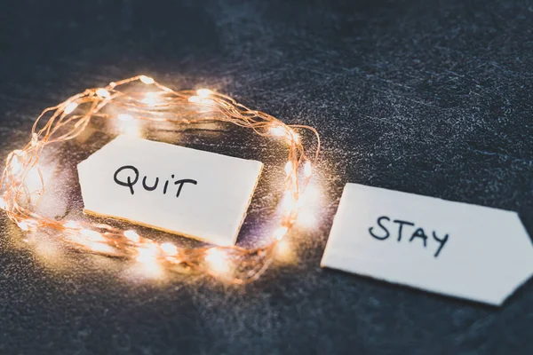 Stay vs quit текст на знаках, указывающих на противоположные направления с — стоковое фото