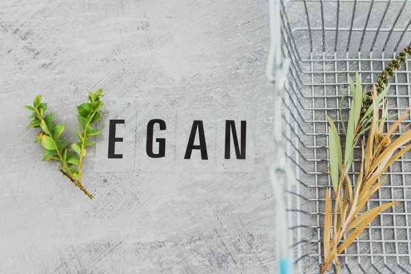 Vegan text with V made from small branches with leaves and shopp — Stock Photo, Image