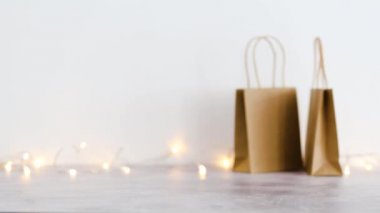 Fiyat etiketi üzerine fiyatlandırma metni olan el çantası ve arka planda peri ışıkları olan diğer çantalar bokeh