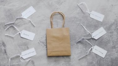 Ürünlerin nasıl pazarlanacağı kavramsal video, üzerinde pazarlama metinleri olan fiyat etiketleriyle çevrili alışveriş çantası ve ödeme kartlarının en üste yerleştirilmesi