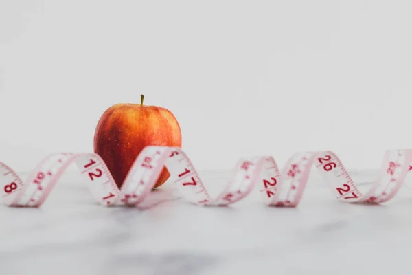 Dieta y nutrición, manzana roja con cinta métrica en shallo — Foto de Stock