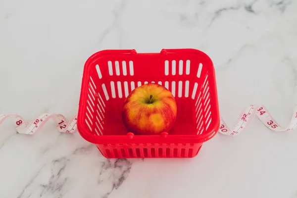 Alimentation et nutrition, pomme rouge avec ruban à mesurer et épicerie — Photo