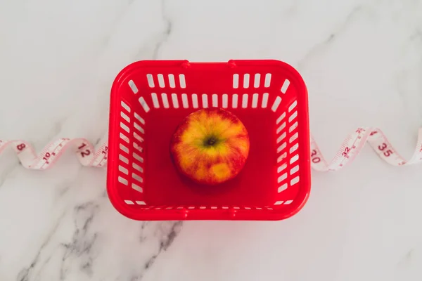 Diet and nutrition, red apple with measuring tape and grocery st — Stock Photo, Image