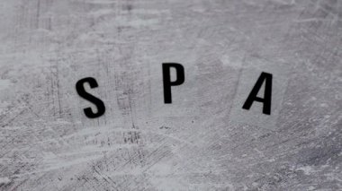 natural beauty products conceptual still-life, lotions and essential oil bottles surrounded by flowers and shells with Spa text camera panning zooming out