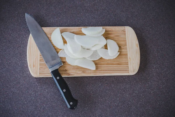 Cuchillo junto a la cebolla picada en la tabla de cortar —  Fotos de Stock