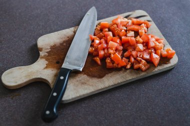 Kesme tahtasındaki bıçaklı domatesler.