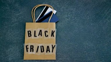 marketing promotional offers and sales conceptual still-life, hand placing Sales price tag next to CBlack Friday shopping bag with payment cards in it