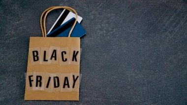 marketing promotional offers and sales conceptual still-life, hand placing shopping basket with world map next to black friday shopping bag