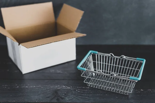 Zakupy online pusta paczka i koszyk zakupów gotowy do użycia — Zdjęcie stockowe