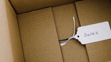 online shopping vs brick and mortar retail, parcel with Sales price tag next to shopping basket with payment cards in it