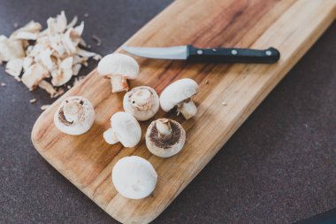 Kesme tahtasında bıçakla doğranmış beyaz porcini mantarları.