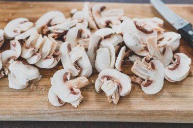 Kesme tahtasında bıçakla doğranmış beyaz porcini mantarları.
