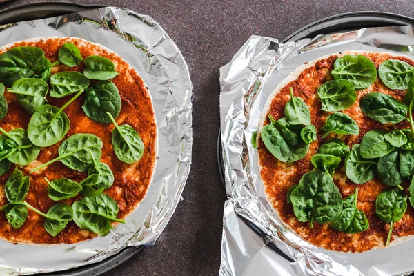 Pizza vegana fatta in casa in preparazione con pomodoro e spinaci come f — Foto Stock