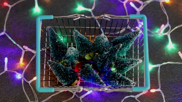 购物篮里摆满了微型圣诞树和仙女灯 准备参加节庆购物 照相机从集中在这个主题上发展到没有集中在Bokeh上 — 图库视频影像