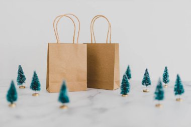 Etrafında minyatür Noel ağaçları olan bir alışveriş çantası.