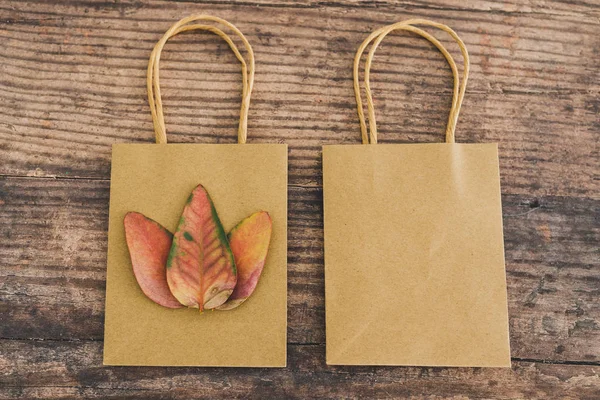 Paper bags with leaves on them symbol of a more ecological alter — Stock Photo, Image