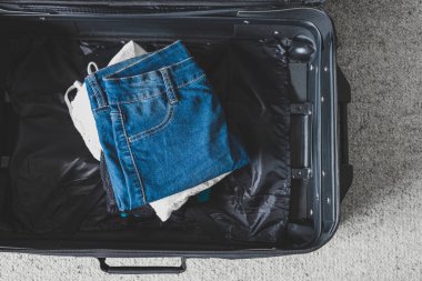 Tatil konsepti için bavul hazırlamak, içinde kıyafet yığını olan bavul