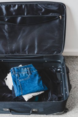 Tatil konsepti için bavul hazırlamak, içinde kıyafet yığını olan bavul