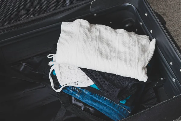 Verpackung für ein Urlaubskonzept, Gepäck mit Kleiderstapeln insi — Stockfoto