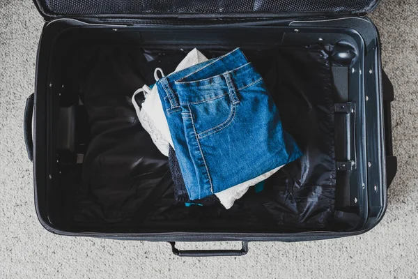 Packing for a holiday concept, luggage with pile of clothes insi — 스톡 사진