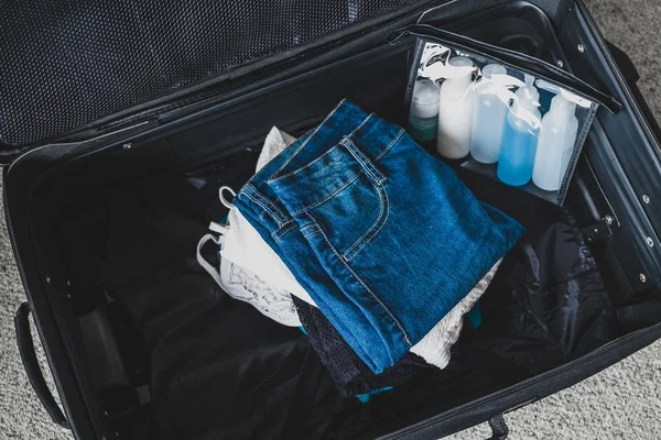 Verpakking licht voor een vakantie concept, bagage met stapel kleding — Stockfoto