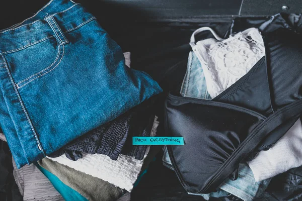 Gepäck mit Stapeln von Kleidung und Verpackung alles Etikett auf der — Stockfoto