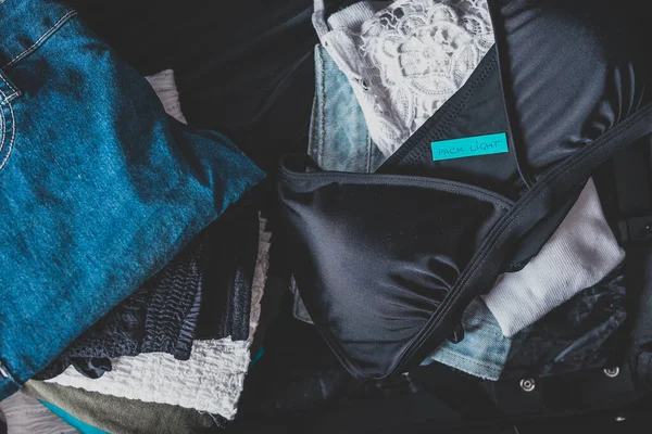 Gepäck mit wenigen Kleidungsstücken im Gepäck und Lichtetikett darauf — Stockfoto