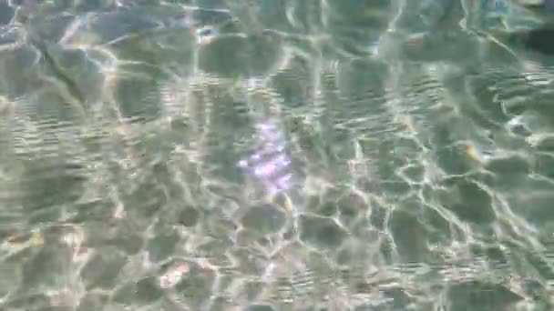 eau claire et fraîche de l'océan Indien prise de vue de dessus la surface avec réflexion de la lumière du soleil sur le sable sous-jacent et ondulations, caméra plongeant sous l'eau à la fin 