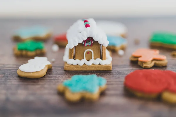 festive gingerbread house and cookies in different colors and sh