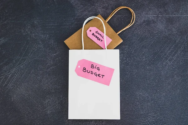 stock image big vs small budget shopping bags with text on price tags