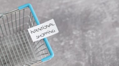 Kasıtlı alışveriş ve sürdürülebilir ürünler kavramsal video, elle yerleştirme boş alışveriş sepeti üzerinde metinler