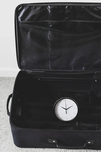 Час подорожі або затримки під час поїздки, порожня валіза з годинником — стокове фото