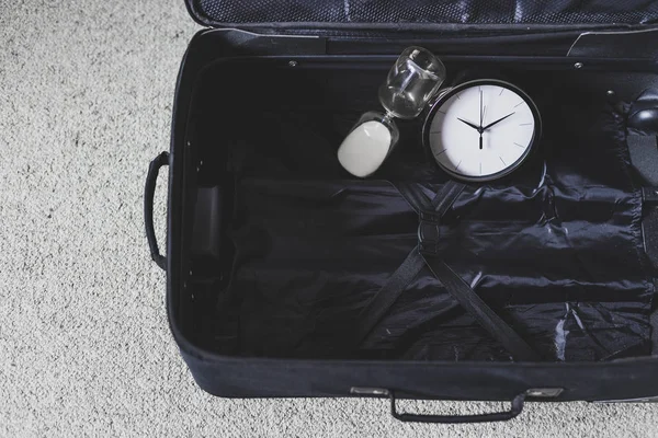 Tiempo para viajar o retrasar durante un viaje, maleta vacía con cloc — Foto de Stock