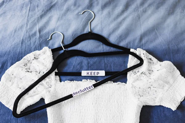 Kleding hangers met witte bovenkant en tekst labels te sorteren tussen i — Stockfoto