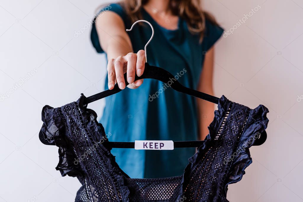 tidying up concept, woman holding clothes hangers with black and