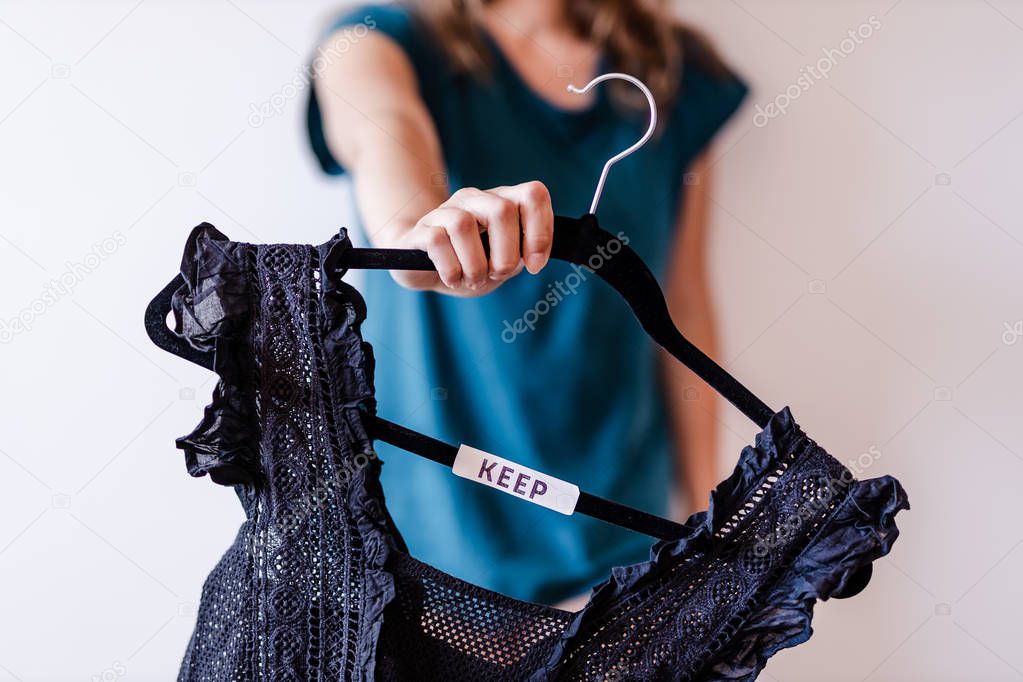 tidying up concept, woman holding clothes hangers with black and