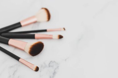yüz ve gözler için mermer masanın üstünde bir grup makyaj fırçası