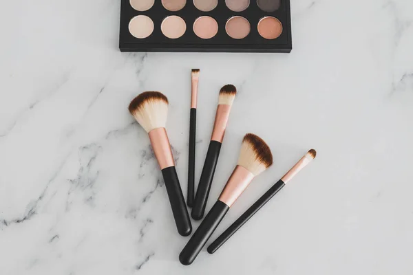 Group of make-up brushes for face and eyes next to palette with — Stock Photo, Image