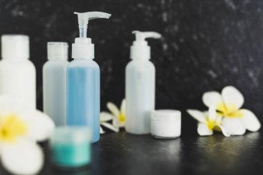 lotions and moisturizer bottles on black marble shot at shallow 