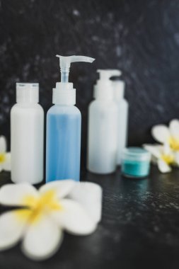 lotions and moisturizer bottles on black marble shot at shallow 