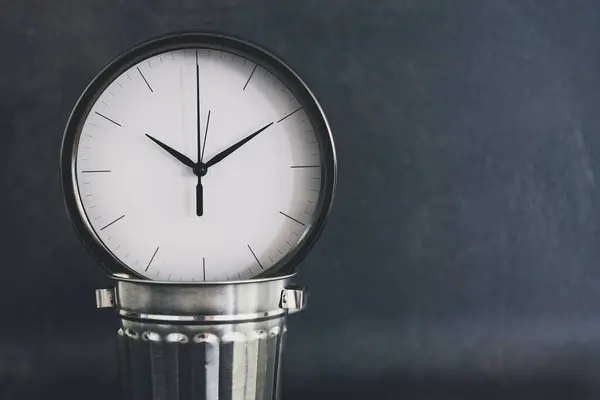 Not wasting time, oversize clock with miniature garbage bin on b — Stock Photo, Image