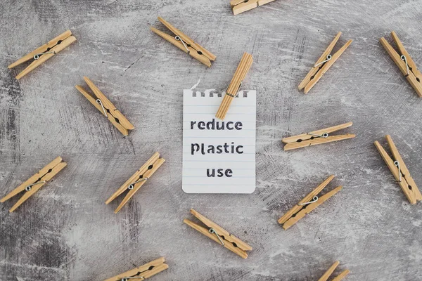 Reducir el mensaje de uso de plástico con clavijas de madera para colgar el lavado , — Foto de Stock