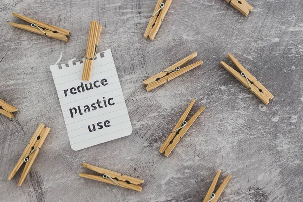 Reducir el mensaje de uso de plástico con clavijas de madera para colgar el lavado , — Foto de Stock