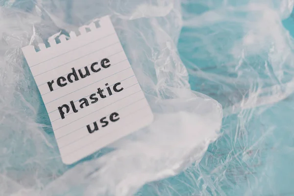 Reducir el mensaje de uso de plástico en la parte superior de un montón de bolsas de plástico, su — Foto de Stock