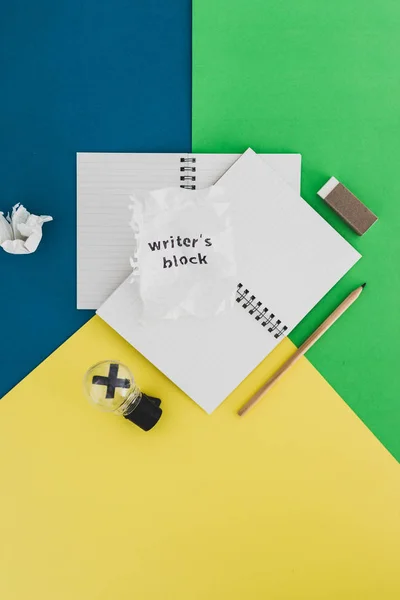 Piece of paper with Writer's Block text on top of blank notepads — Stock Photo, Image